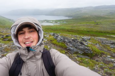 Selfie Skarsvag (yakın Nordkapp) yakınlarındaki tepe üzerinde yapma turist adam. Lofoten Adaları dönüm noktası. Norveç.