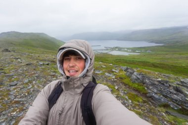 Selfie Skarsvag (yakın Nordkapp) yakınlarındaki tepe üzerinde yapma turist adam. Lofoten Adaları dönüm noktası. Norveç.