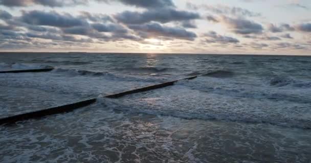 Breakwater van lariks logboeken. Versterking van de kust om het zand op het strand te houden. Prachtige zonsondergang in Zelenogradsk, Rusland. — Stockvideo