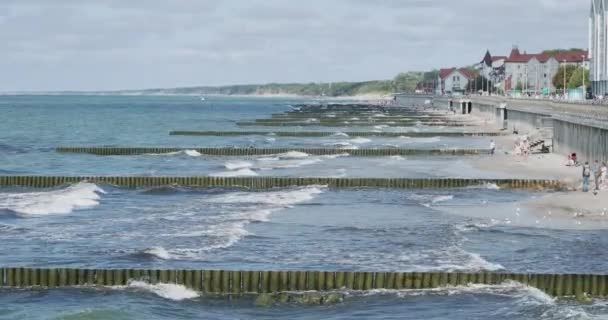 ZELENOGRADSK, RUSSIA - July 20, 2019. Tourists on promenade. Sea embankment. Breakwater of larch logs. — ストック動画