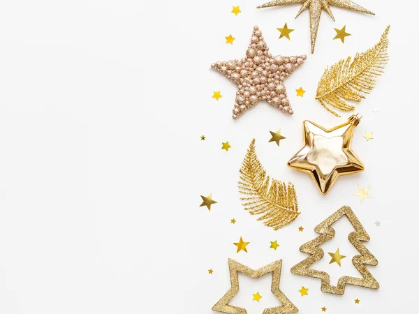 Altın Yeni Yıl süslemeleri. Parlak parlak tüyler ya da yapraklar, Noel ağacı için köknar ağacı ve yıldız konfetileri. Üst manzara, düz uzanma.