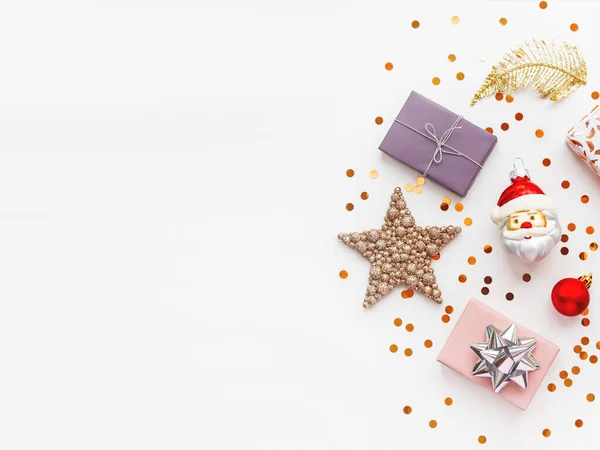 Vánoce a Nový rok 2020 pozadí s dekoracemi. Santa Claus, zlaté peří, dárky a hvězdy konfety. — Stock fotografie