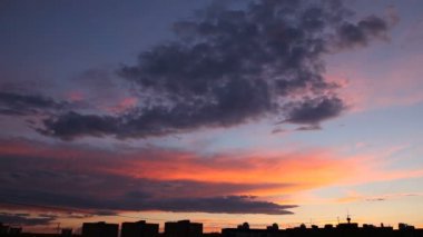 Zaman atlamalı klip günbatımı gökyüzü üzerinde kabarık bulutlar. Akşam cityscape, binalar silüeti. Güzel cennet.