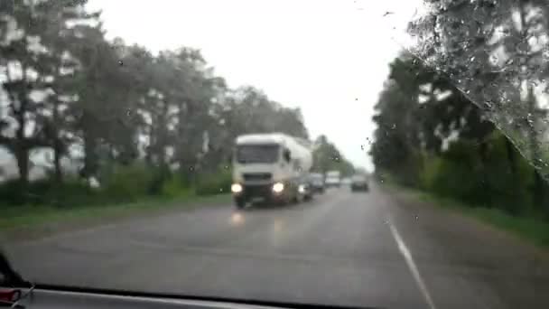 Een roadtrip bij slecht weer. De ruitenwissers verwijderen regendruppels uit de voorruit van de auto. — Stockvideo