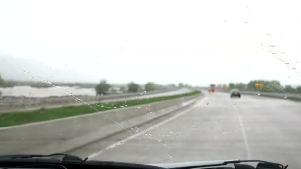 Vägresa i dåligt väder. Torkarna tar bort regndroppar från bilens vindruta. — Stockvideo