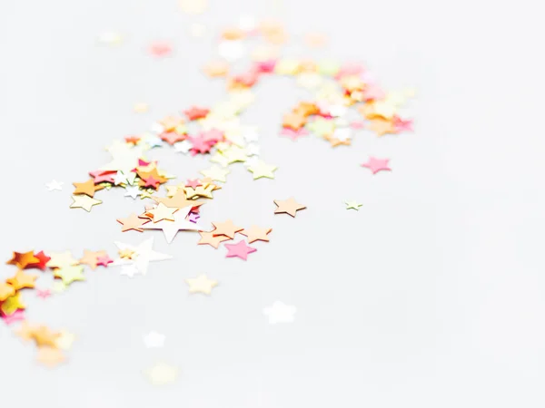 Fehér ünnep háttér színes csillag konfetti. Jó háttér a karácsonyi és újévi kártyák. — Stock Fotó
