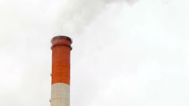 Cheminée de chaufferie. Vapeur contre le ciel nuageux enneigé. Zone industrielle de la ville . — Video