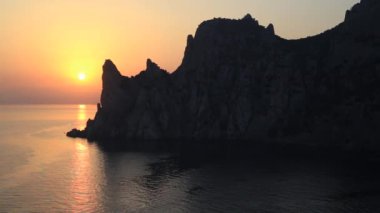 Karaul-Oba Dağı 'nın silueti, Jurasik dönemin antik mercan resifinin kıyısında. Cape Kapchik 'ten gergedan şeklinde gün batımı manzarası. Kırım.