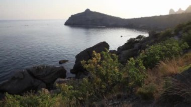 Karaul-Oba Dağı 'nın silueti, Jurasik dönemin antik mercan resifinin kıyısında. Kapchik Burnu ve gergedan şeklinde dağda gün batımı manzarası. Kırım.