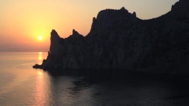 Karaul-Oba Dağı 'nın silueti, Jurasik dönemin antik mercan resifinin kıyısında. Cape Kapchik 'ten gergedan şeklinde gün batımı manzarası. Kırım.