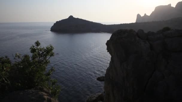 Silhouette of Karaul-Oba mount, edge of the ancient coral reef of the Jurassic period. Sunset view on mountain in shape of rhinocerous and cape Kapchik. Crimea. — Stock Video