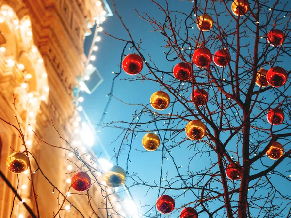 Straten van Moskou ingericht voor Nieuwjaar en Kerstmis viering. Boom met heldere rode en gele ballen. Kauwgom (Main warenhuis) gebouw met lampen. Rusland. — Stockfoto