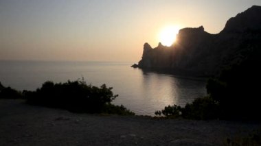 Karaul-Oba Dağı 'nın silueti, Jurasik dönemin antik mercan resifinin kıyısında. Cape Kapchik 'ten gergedan şeklinde gün batımı manzarası. Kırım.