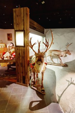 Rovaniemi, Finlandiya - 20 Temmuz 2017. Kutup dairesi yakınlarındaki Santa Claus köyündeki müzede sergi. Mankenler Noel Baba 'nın gelişini sıradan bir Fin ailesine hediyelerle tasvir ederler..