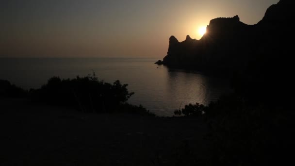 Silueta del monte Karaul-Oba, borde del antiguo arrecife de coral del período Jurásico. Vista del atardecer en la montaña en forma de rinoceronte desde el cabo Kapchik. Crimea . — Vídeo de stock