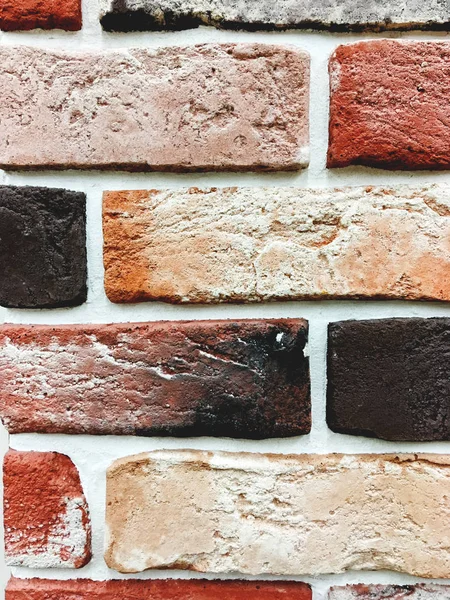 Parete esterna in mattoni arancio e marrone con cemento bianco. Struttura di pietra di muro di edificio . — Foto Stock