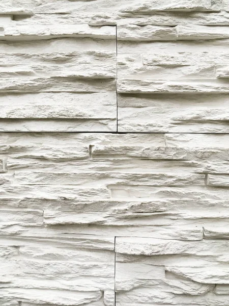 Ściana zewnętrzna z białych kamieni dekoracyjnych. Kamienna faktura ściany budynku. — Zdjęcie stockowe