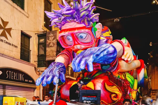 VALLETTA, MALTA - 13 de febrero de 2010. Fiesta nocturna tradicional. Carnaval con muñecas gigantes en movimiento y gente en trajes coloridos . — Foto de Stock