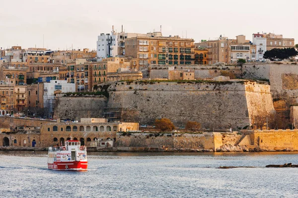 VALLETA, MALTA - 13 febbraio 2010. Nave turistica passa le antiche mura di La Valletta . — Foto Stock