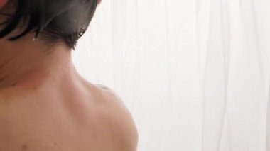 Woman shaves her armpits with a razor. Slow motion video in bathroom. Close up video of wet skin.