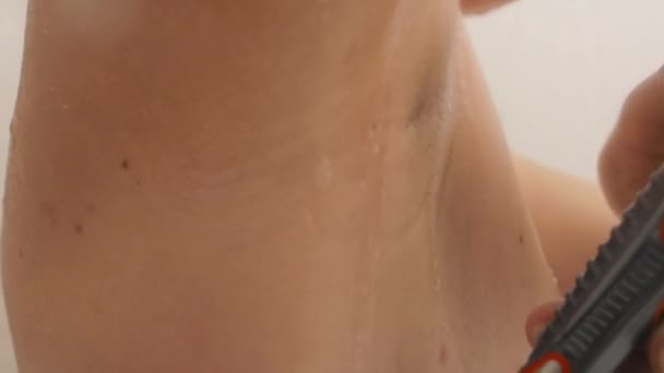 Vrouw scheert haar oksels met een scheermes. Slow motion video in de badkamer. close-up video van natte huid. — Stockvideo