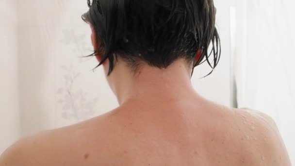 Naked woman takes a shower. Woman washes her short hair with shampoo. Slow motion video in white bathroom. — Stock Video