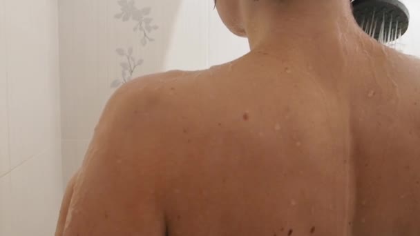 벌거벗은 여자가 샤워를 한다. 여자는 짧은 머리를 씻는다. 흰색 화장실에서의 느린 모션 비디오. — 비디오
