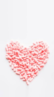 Pembe haplardan yapılmış bir kalp. Kalp şeklinde uyuşturucuyla ilgili en iyi bakış açısı. Kopyalama alanı olan düz beyaz arkaplan.
