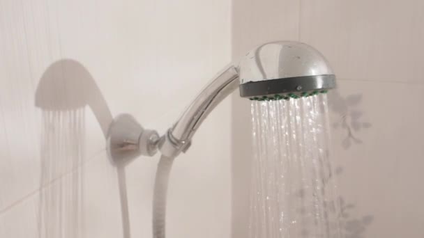 Wasserströme. Duschkopf aus Metall im weißen Badezimmer. Arbeitsfähige Sanitärausrüstung. — Stockvideo