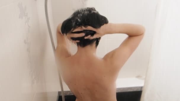 Femme nue prend une douche. Femme se lave les cheveux courts avec un shampooing. Vidéo au ralenti dans la salle de bain blanche . — Video