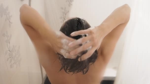 Nackte Frau nimmt eine Dusche. Frau wäscht ihre kurzen Haare mit Shampoo. Zeitlupenvideo im weißen Badezimmer. — Stockvideo