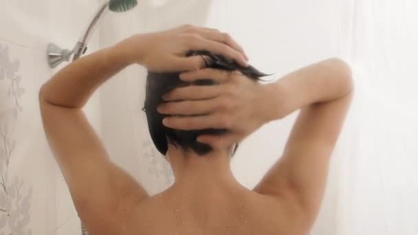 Mulher nua toma banho. A mulher lava o cabelo curto com champô. Vídeo em câmera lenta no banheiro branco . — Vídeo de Stock