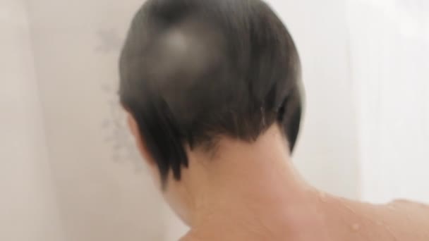 Naked woman takes a shower. Woman washes her short hair . Slow motion video in white bathroom. — Stock Video