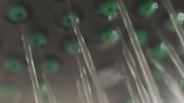 Su akıntıları. Beyaz banyodaki metal duş başlığının yakın görüntüsü. Çalışan tesisat ekipmanı.