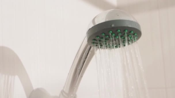 Proudy vody. Kovová sprchová hlava v bílé koupelně. Pracovní instalatérské zařízení. — Stock video