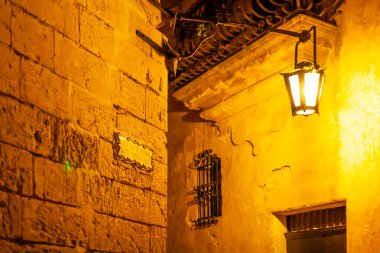 Mdina 'nın dar sokakları, eski Malta' nın başkenti. Aydınlatılmış binalar ve antik şehrin duvar süslemeleri üzerine gece görüşü.
