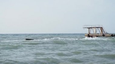 Deniz manzaralı güzel bir hava. Sahilden eski paslı iskelenin manzarası. Soçi, Rusya.