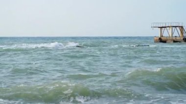 Deniz manzaralı güzel bir hava. Sahilden eski paslı iskelenin manzarası. Soçi, Rusya.