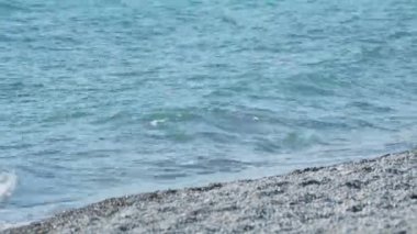 Kayalık sahilde deniz sörfü. Güneşli bir günde sakin doğal bir arka plan. Karadeniz, Soçi, Rusya.