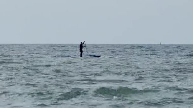 Sup panosunda kürek çeken bir adam. Kalk ve sörf yap. Karadeniz, Soçi, Rusya 'da su sporu.