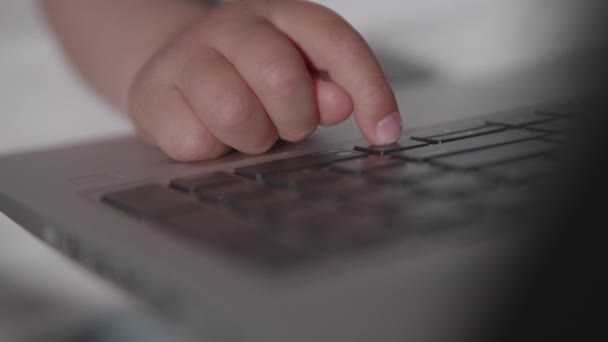 Mor och hennes barn sitter tillsammans på en stol med laptop. Kvinnan försöker arbeta på distans, men grabben ber om spel eller tecknade serier. Karantänavstängning på grund av coronavirus COVID-19. 10bit V-logL — Stockvideo