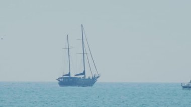 Korsan yelkenli gibi görünen turistik tekne dalgaların arasında sallanıyor. Soçi, Rusya.