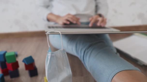 Mama i syn siedzą w domowej kwarantannie z powodu koronawirusu COVID19. Matka pracuje zdalnie z laptopem, syn bawi się klockami. Samoizolacja w domu. — Wideo stockowe