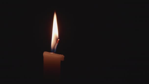 Vista de perto sobre a vela queimando na escuridão. Chama constante alta mal se move acima da parafina . — Vídeo de Stock