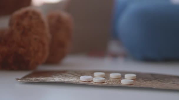 O miúdo brinca com drogas dispersas. A criança toca em pílulas sem controle dos pais. Situação perigosa . — Vídeo de Stock