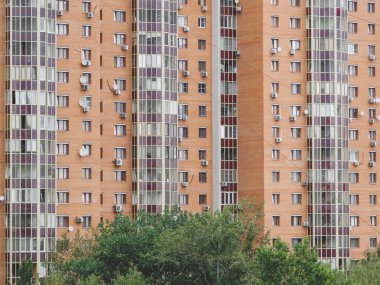 Modern apartman dairesi. Binanın duvarlarında bir sürü klima ve uydu plakası var.. 