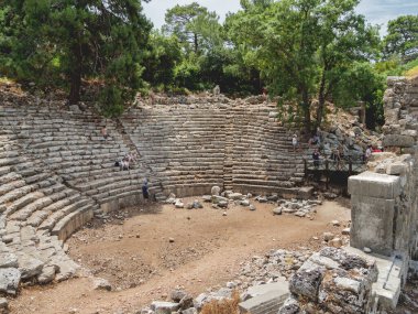 PHASELIS, TÜRKÇE 19 Mayıs 2018. Turistler antik Phaselis şehrinin amfitiyatrosunun kalıntılarına doğru yürüyorlar. Antalya 'nın Kemer ilçesinde ünlü mimari simgesi üzerine panorama manzarası.