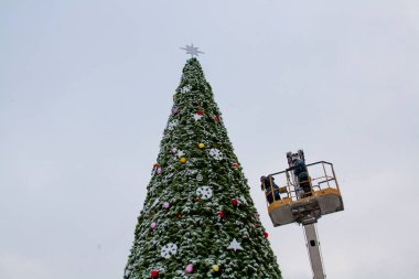 İşçiler bir Noel ağacı süslemeleri 