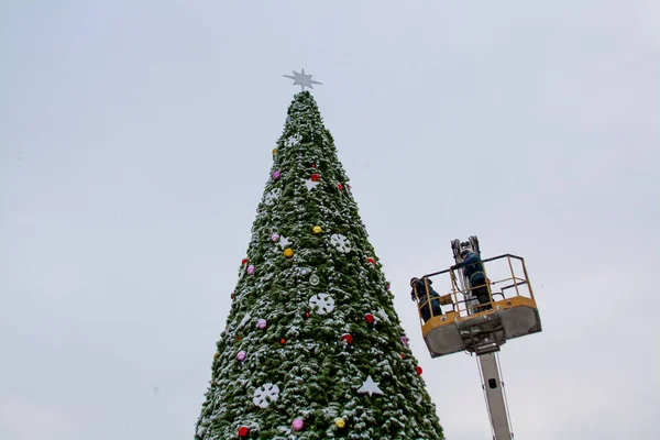 İşçiler bir Noel ağacı süslemeleri 