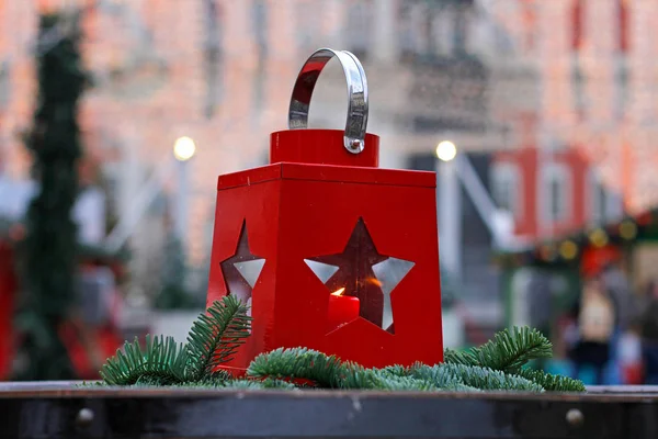 Linterna roja con la vela dentro de pie sobre la mesa en el festival de Navidad — Foto de Stock